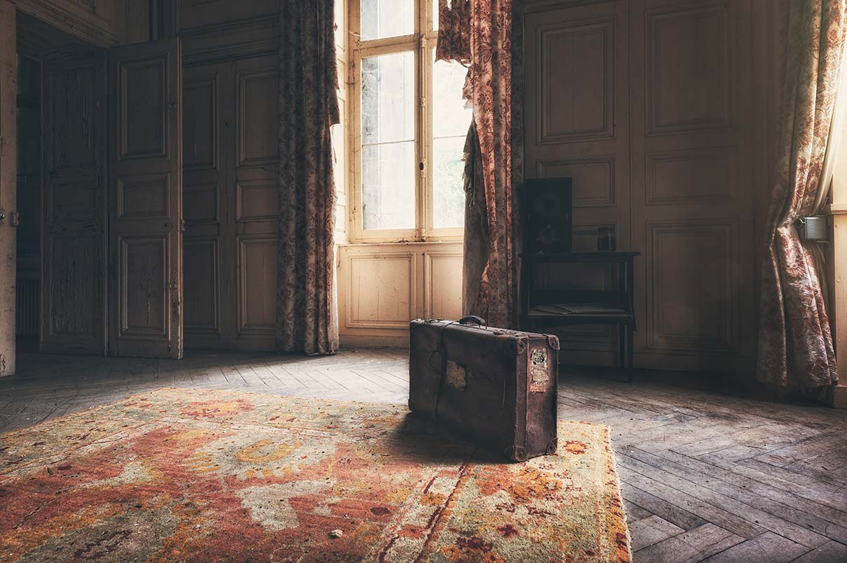 A lone suitcase in a shabby room